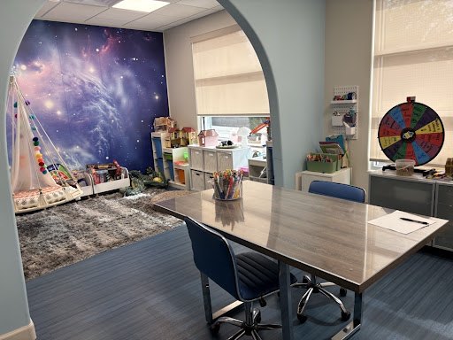 The galaxy room at Artplay — a glowing space mural, a garlanded teepee, and a big worktable ready for art
