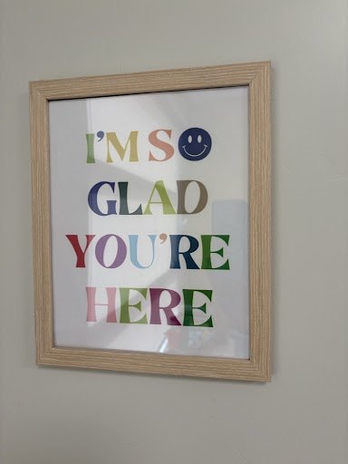 A framed print by the door that reads: I'm so glad you're here