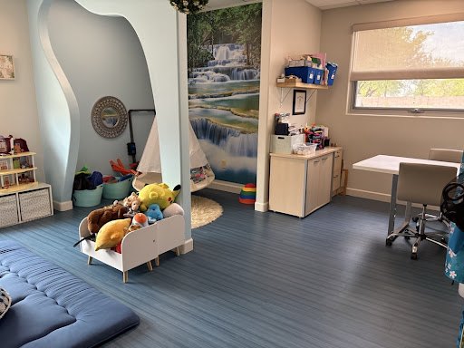 The waterfall room — a floor-to-ceiling waterfall mural, a white canopy, and a wagon full of stuffed animals
