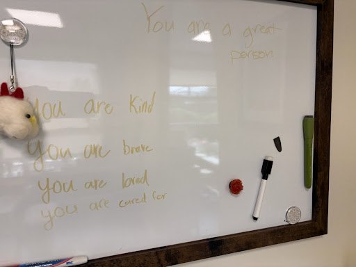 A whiteboard where someone has written: you are kind, you are brave, you are loved, you are cared for